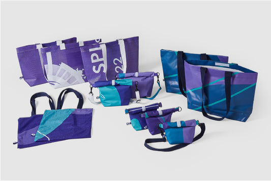 Die Kollektion "upgecycelte Taschen" in verschiedenen Blau- und Violetttönen aus den Materialien der Nationalen Spiele 2022. 