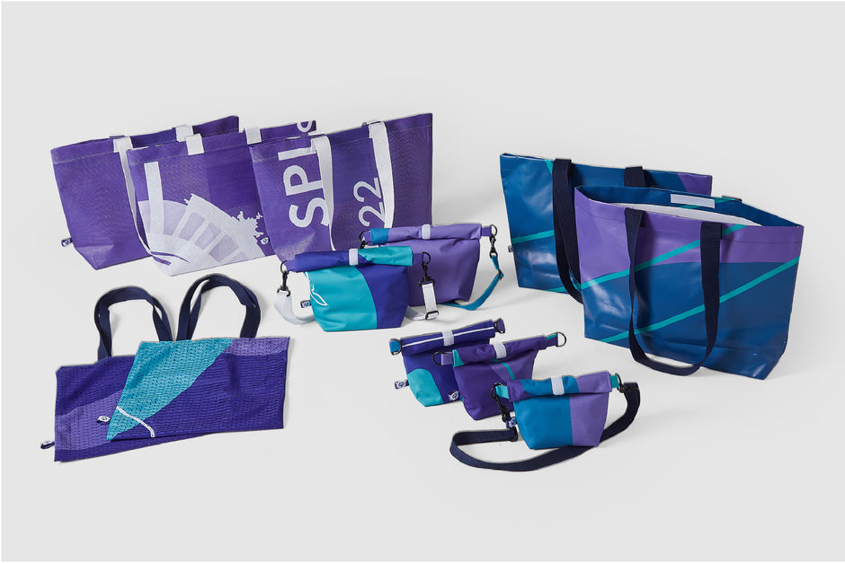 Die Kollektion "upgecycelte Taschen" in verschiedenen Blau- und Violetttönen aus den Materialien der Nationalen Spiele 2022. 