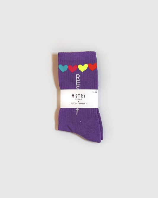 Violette Socken mit der Aufschrift Respect und bunten Herzen in der Papierverpackung