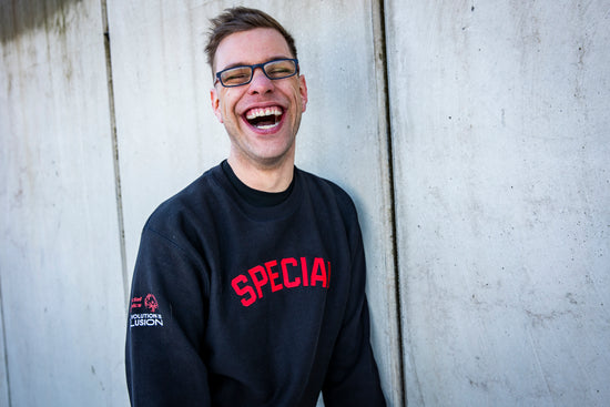 Frontansicht des Special Pullovers präsentiert von einem herzhaft lachenden Athleten