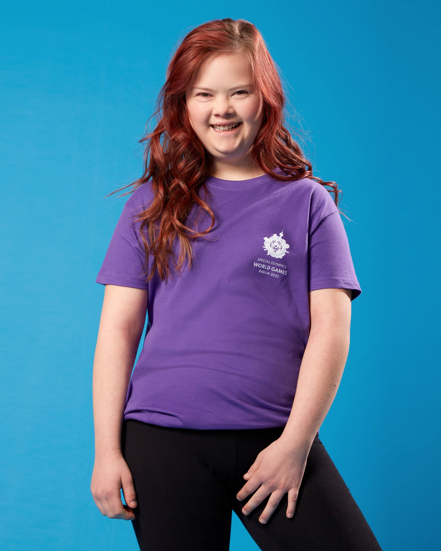 Mädchen trägt violettes T-Shirt mit kleinem Weltspiele Logo auf der Brust
