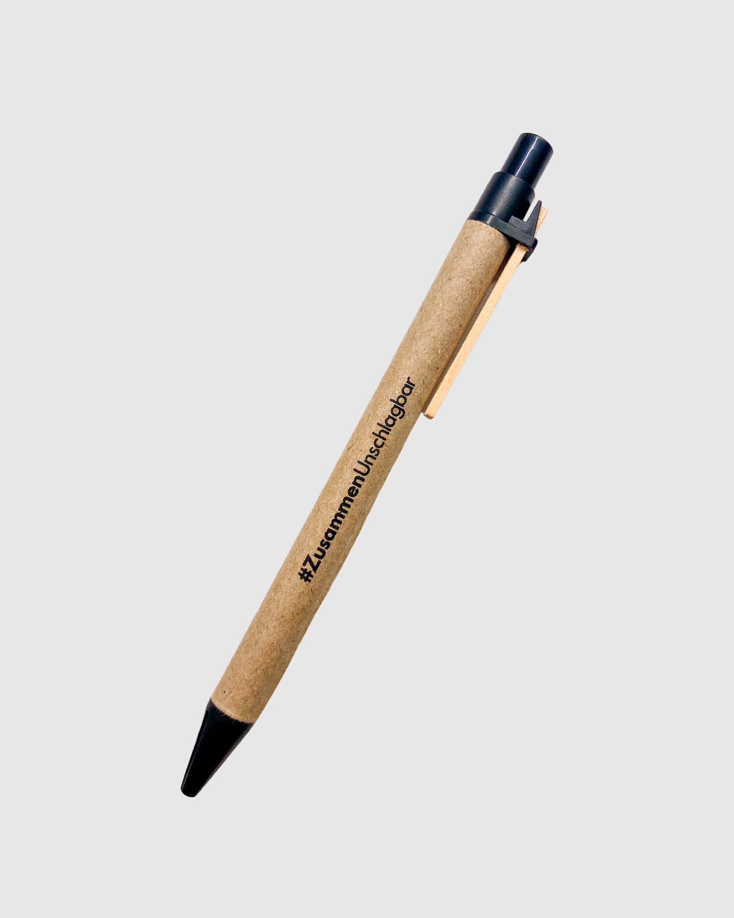 Kugelschreiber aus recycelter Pappe mit schwarzen Details und schwarzem Aufdruck des #ZusammenUnschlagbar-Mottos.
