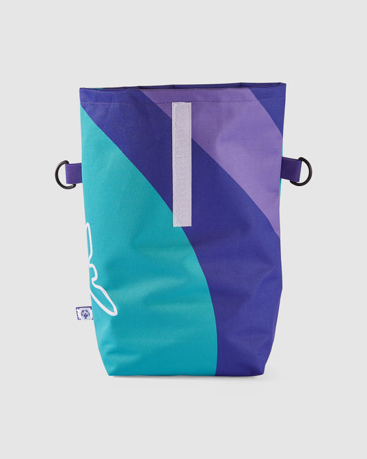 Frontseite der geöffneten Rolltop Tasche mit hellblauem, dunkelblauem und violettem Muster. 