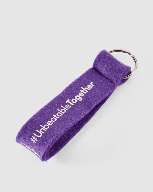 Schlüsselanhänger in violett mit weißem #UnbeatableTogether Schriftzug hinten