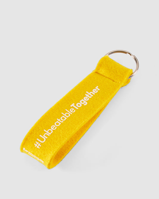 Schlüsselanhänger in gelb mit weißem #UnbeatableTogether Schriftzug hinten